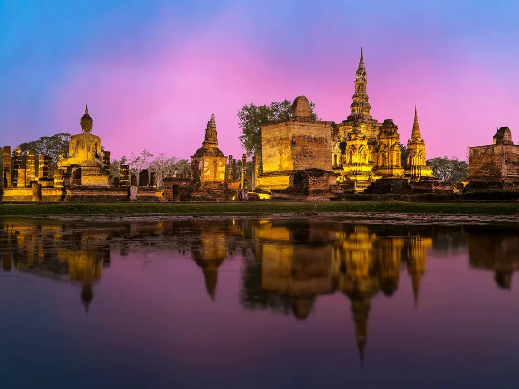 Serene lit up village reflected in water